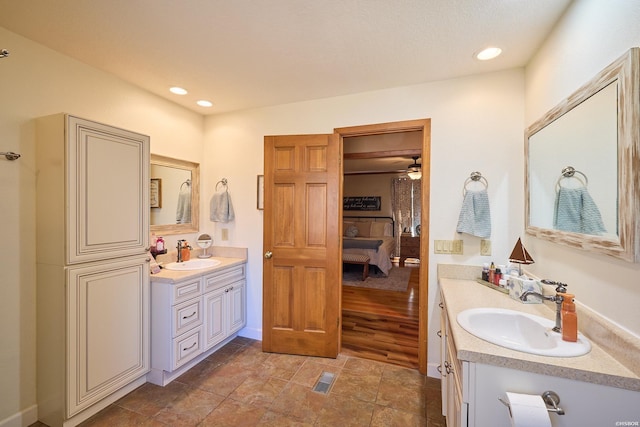 bathroom with a sink, two vanities, connected bathroom, and recessed lighting