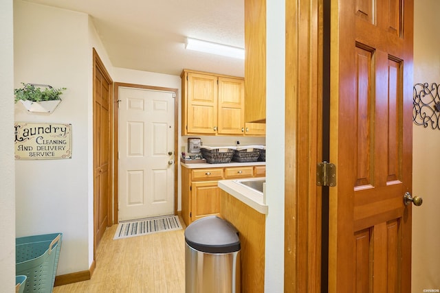 kitchen with light countertops, light brown cabinetry, and light wood-type flooring