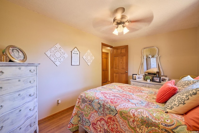 bedroom featuring a ceiling fan, light wood-style flooring, and a textured ceiling