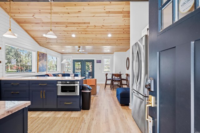 kitchen featuring appliances with stainless steel finishes, light countertops, french doors, light wood-style floors, and pendant lighting