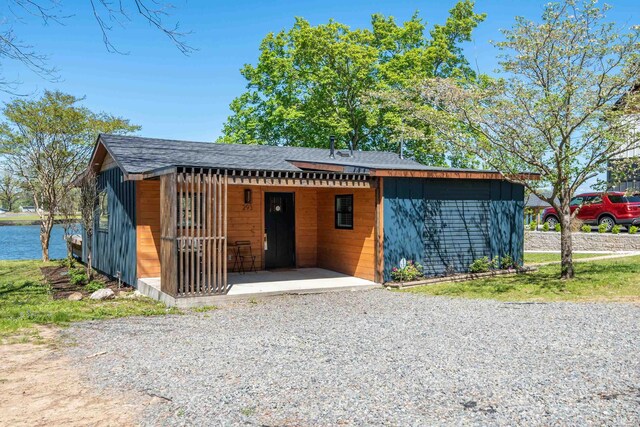 view of front of property featuring a shingled roof and a water view