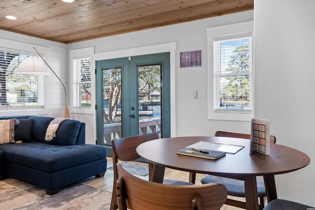 dining room with french doors, wooden ceiling, and light wood-style floors