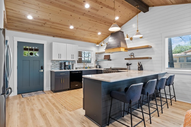 kitchen featuring open shelves, appliances with stainless steel finishes, white cabinets, a peninsula, and a kitchen bar