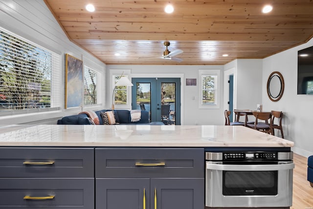 kitchen with light stone countertops, wood ceiling, gray cabinets, and oven