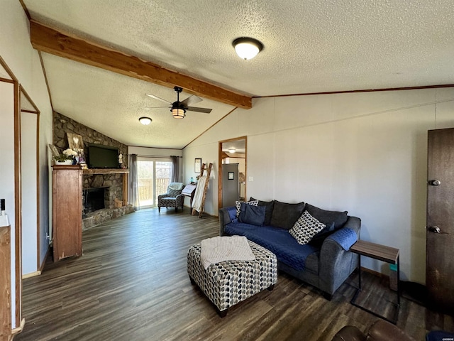 living room with ceiling fan, a stone fireplace, wood finished floors, and vaulted ceiling with beams