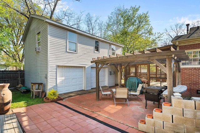 rear view of property featuring an attached garage, fence, a patio, and a pergola