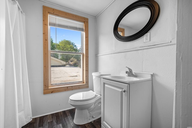 bathroom with toilet, wood finished floors, vanity, and baseboards