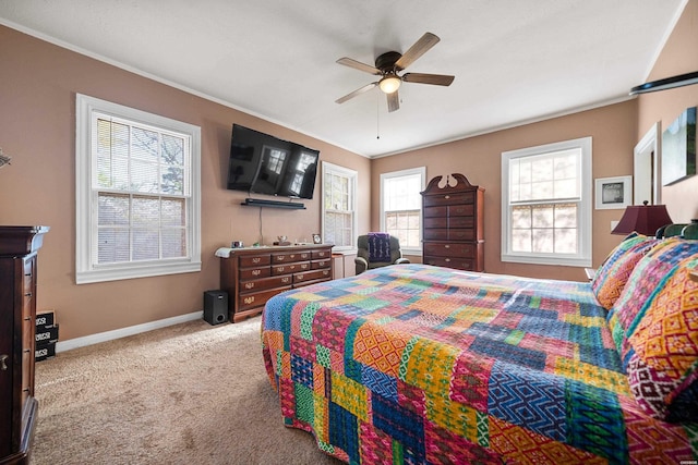 carpeted bedroom with crown molding, baseboards, and ceiling fan