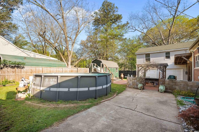 view of pool with an outbuilding, a shed, a pergola, a fenced backyard, and a fenced in pool