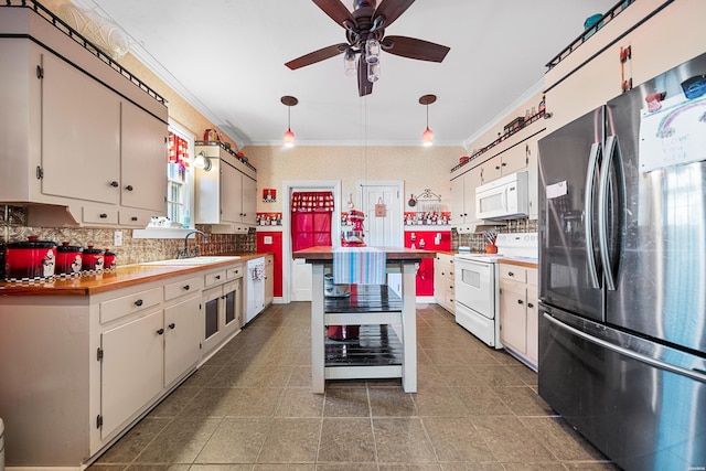 kitchen featuring ceiling fan, white appliances, dark tile patterned flooring, ornamental molding, and decorative backsplash