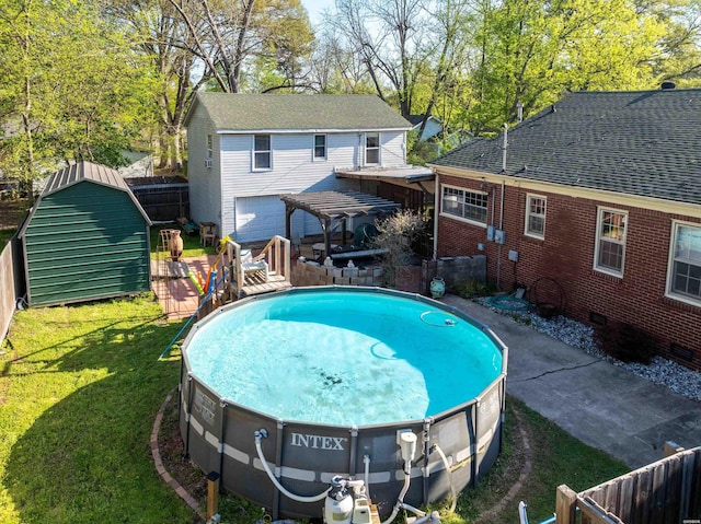 view of swimming pool with a fenced in pool, a fenced backyard, a wooden deck, an outbuilding, and a lawn