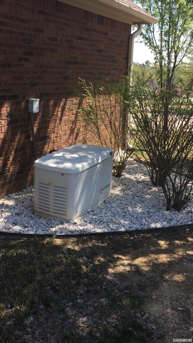 exterior details featuring a power unit and brick siding