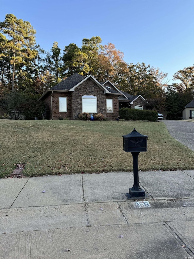 exterior space with brick siding and a front lawn