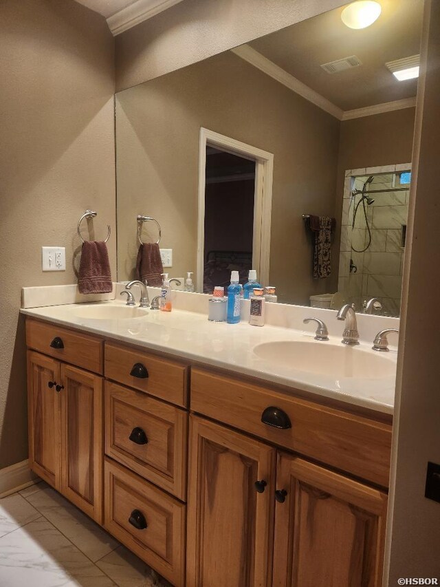 full bath with double vanity, crown molding, visible vents, and a sink