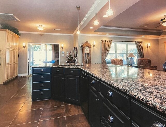 kitchen with a tray ceiling, dark cabinets, visible vents, and a healthy amount of sunlight