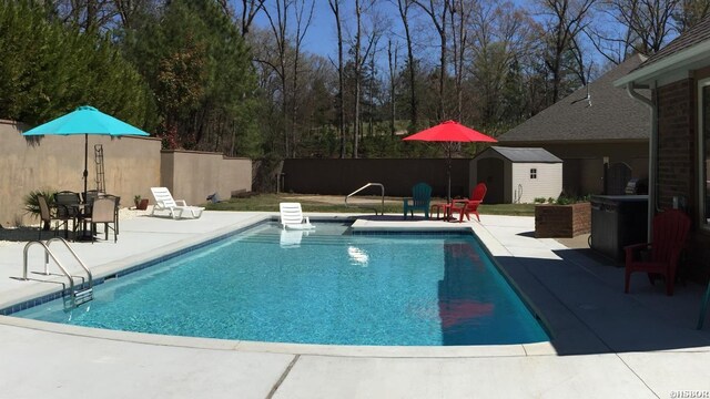 view of pool with a storage shed, a fenced backyard, a patio, and an outdoor structure