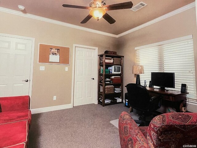 home office featuring carpet floors, visible vents, a ceiling fan, and ornamental molding