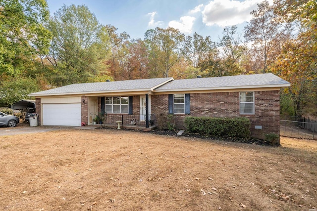 ranch-style home with driveway, brick siding, an attached garage, and fence