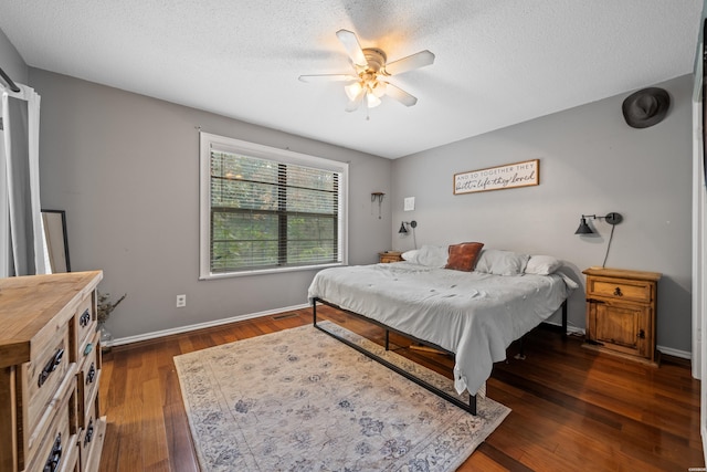 bedroom featuring ceiling fan, a textured ceiling, baseboards, and wood finished floors