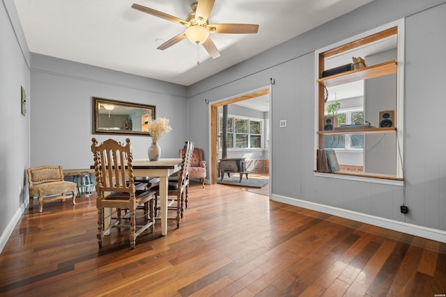 dining space with baseboards, a ceiling fan, and hardwood / wood-style flooring