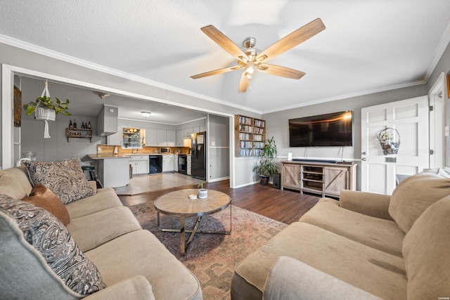 living area with a textured ceiling, wood finished floors, a ceiling fan, and ornamental molding