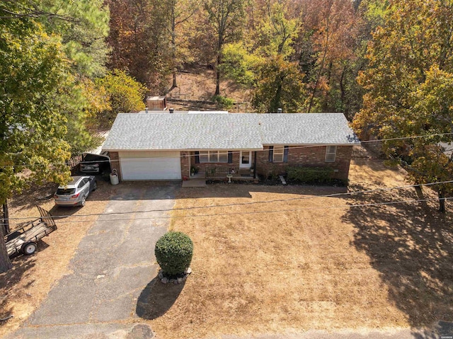 view of front of house featuring aphalt driveway, brick siding, a garage, and roof with shingles