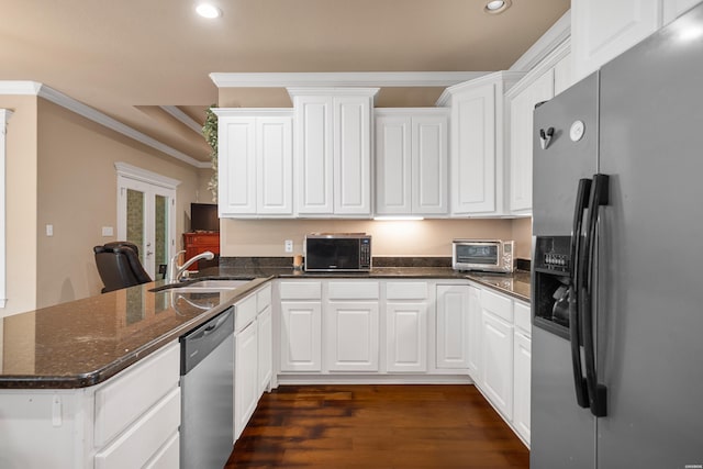 kitchen featuring a peninsula, a sink, stainless steel appliances, dark wood-style flooring, and recessed lighting
