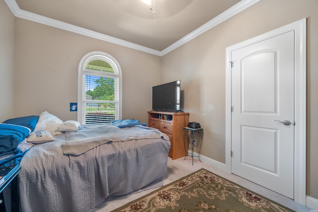 bedroom featuring light colored carpet, baseboards, a ceiling fan, and ornamental molding