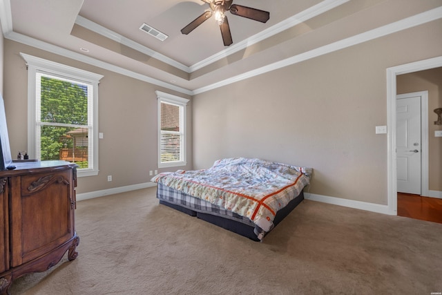 bedroom featuring crown molding, a raised ceiling, light colored carpet, and visible vents