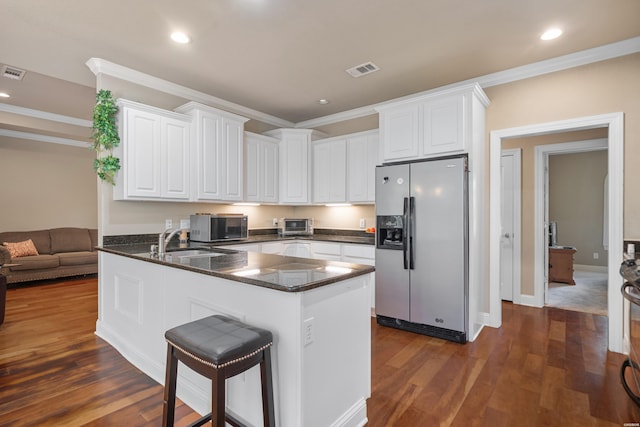 kitchen featuring a peninsula, appliances with stainless steel finishes, visible vents, and white cabinetry