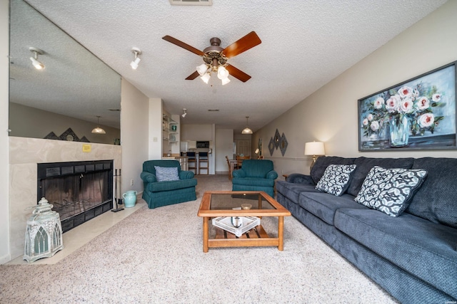 5371 Central Ave Unit 5D, Hot Springs, AR 71913 - carpeted living area featuring lofted ceiling, ceiling fan, a textured ceiling, a tile fireplace, and visible vents