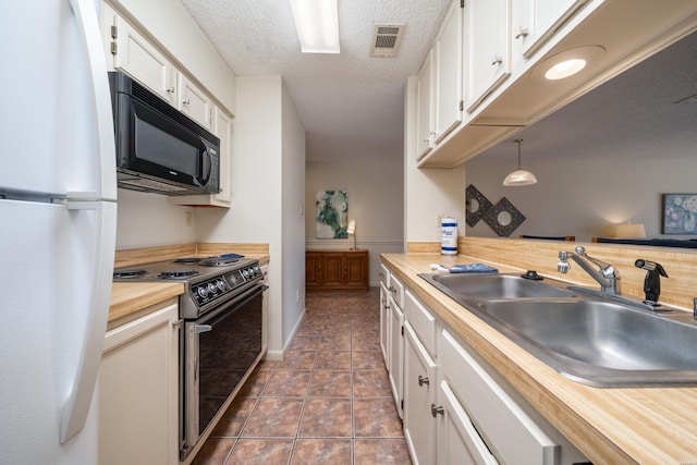 5371 Central Ave Unit 5D, Hot Springs, AR 71913 - kitchen with decorative light fixtures, electric range, freestanding refrigerator, white cabinetry, and black microwave
