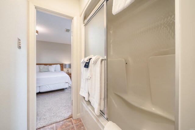 5371 Central Ave Unit 5D, Hot Springs, AR 71913 - full bathroom featuring visible vents, a shower with shower door, ensuite bathroom, tile patterned flooring, and a textured ceiling