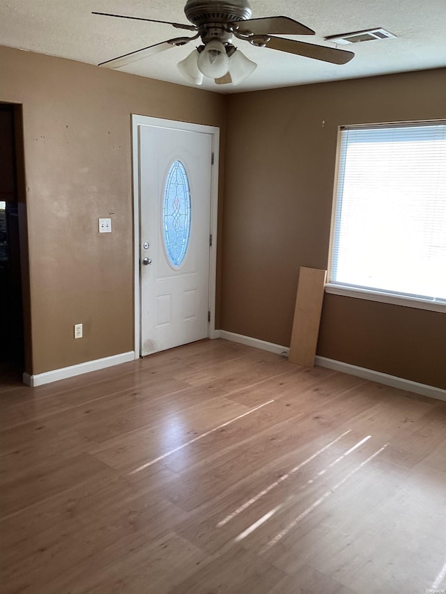 entryway featuring wood finished floors, visible vents, and baseboards