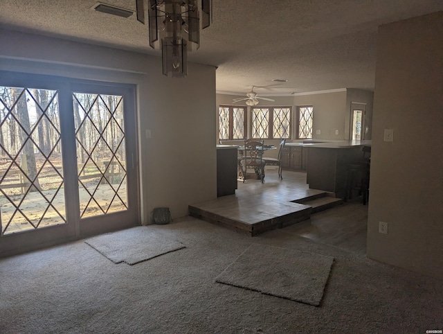 entryway with light carpet, ceiling fan, and a textured ceiling