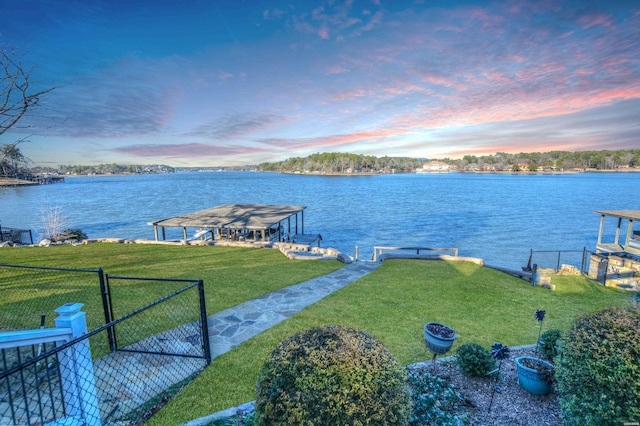 exterior space with a water view, fence, and a yard