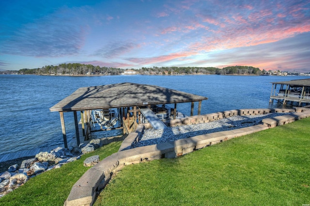 view of dock with a yard, a water view, and boat lift