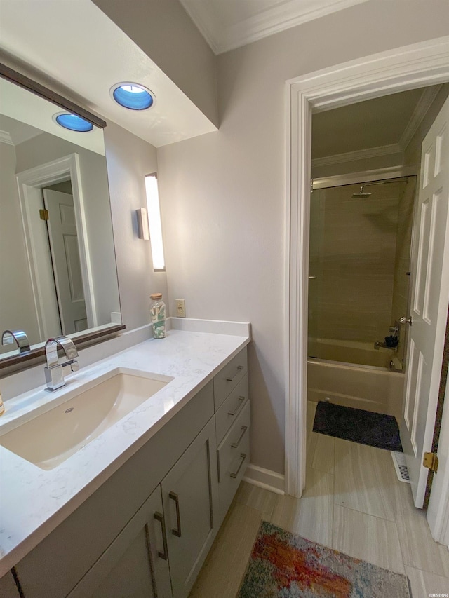 bathroom with bath / shower combo with glass door, ornamental molding, vanity, and baseboards