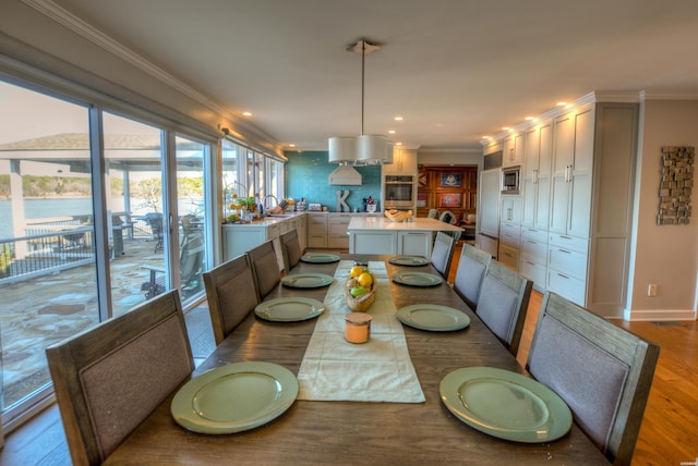 dining area with recessed lighting, crown molding, baseboards, and wood finished floors