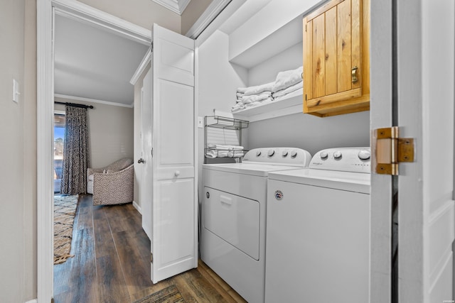 washroom featuring cabinet space, ornamental molding, washer and clothes dryer, and dark wood-type flooring