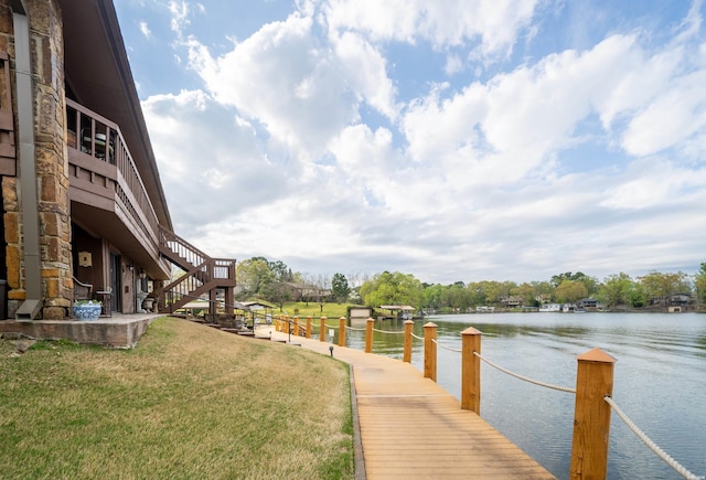 dock area featuring a water view, a yard, and stairway