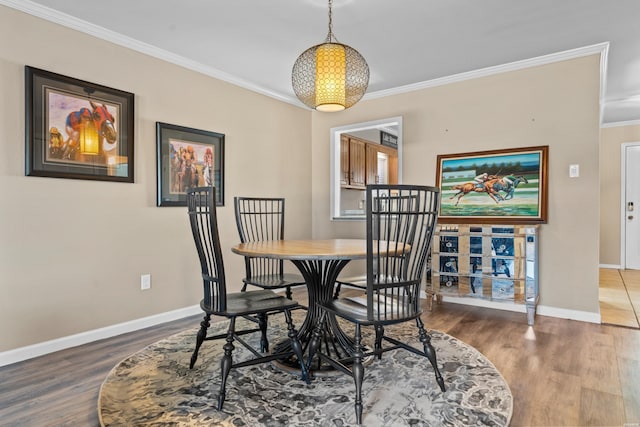 dining room featuring baseboards, wood finished floors, and crown molding