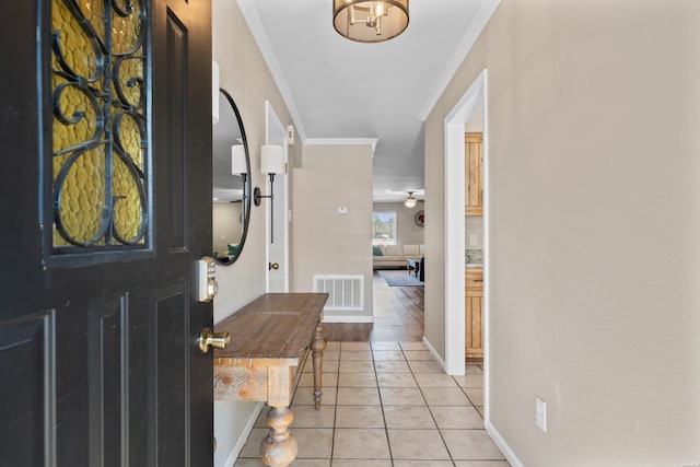 entryway featuring crown molding, light tile patterned floors, visible vents, ceiling fan, and baseboards