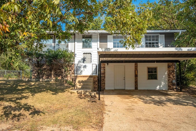 view of front of property featuring driveway, fence, a front lawn, and a carport