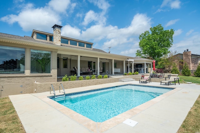 outdoor pool with outdoor lounge area and a patio area