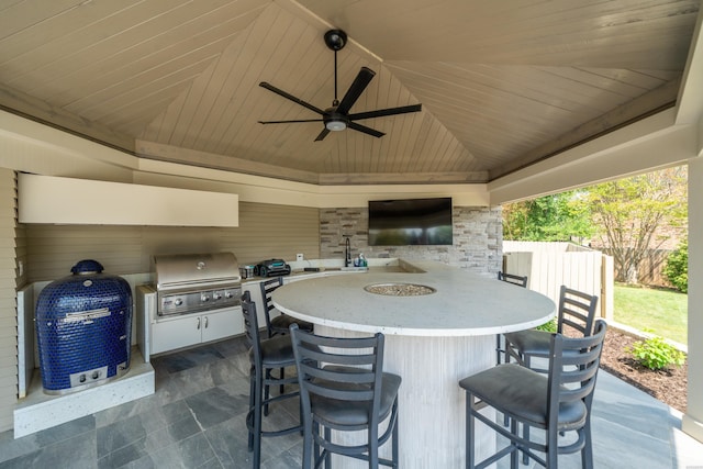 view of patio featuring area for grilling, a ceiling fan, outdoor wet bar, and fence