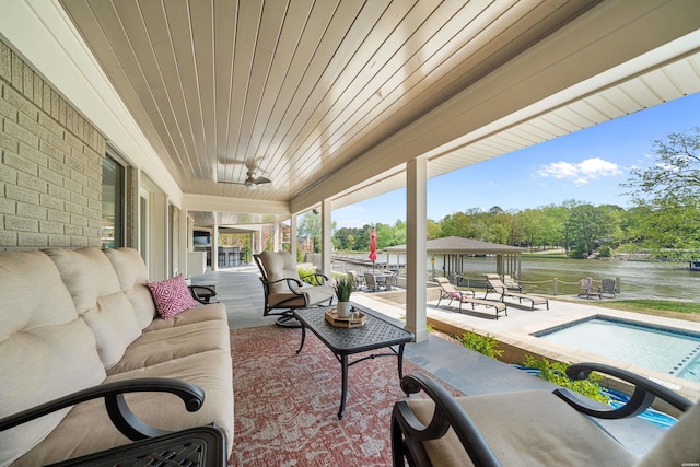 view of patio featuring outdoor lounge area, a water view, and an outdoor pool