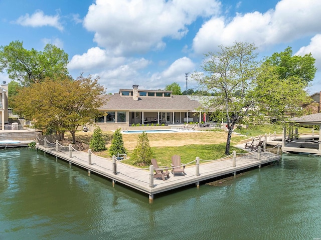 back of house with an outdoor pool and a water view