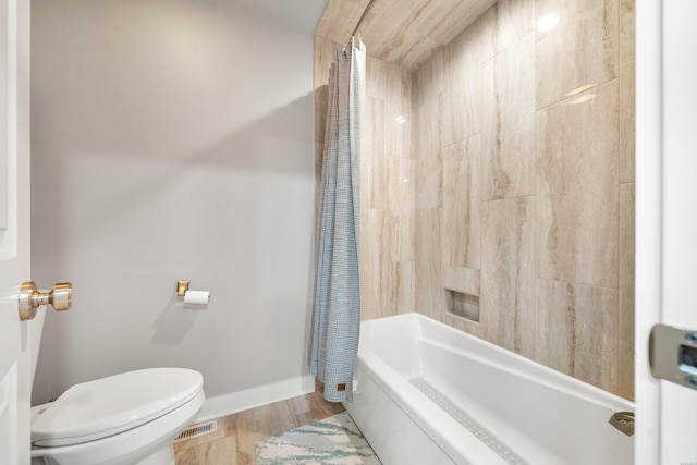 bathroom with wood finished floors, shower / bath combination with curtain, toilet, baseboards, and visible vents
