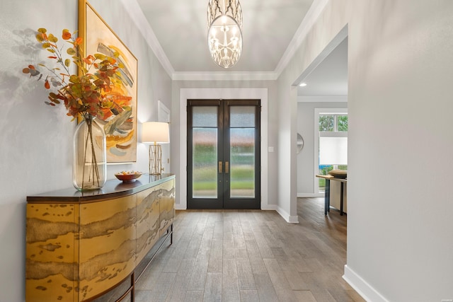doorway featuring an inviting chandelier, crown molding, baseboards, french doors, and wood finished floors